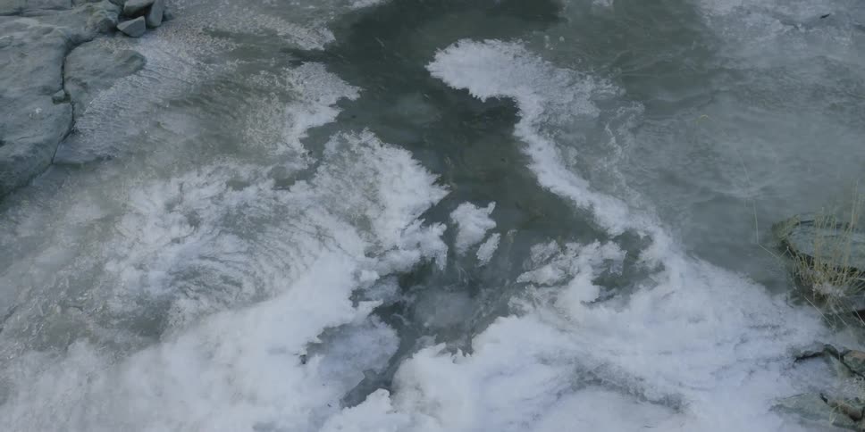 A trickle of water moves through an icy stream