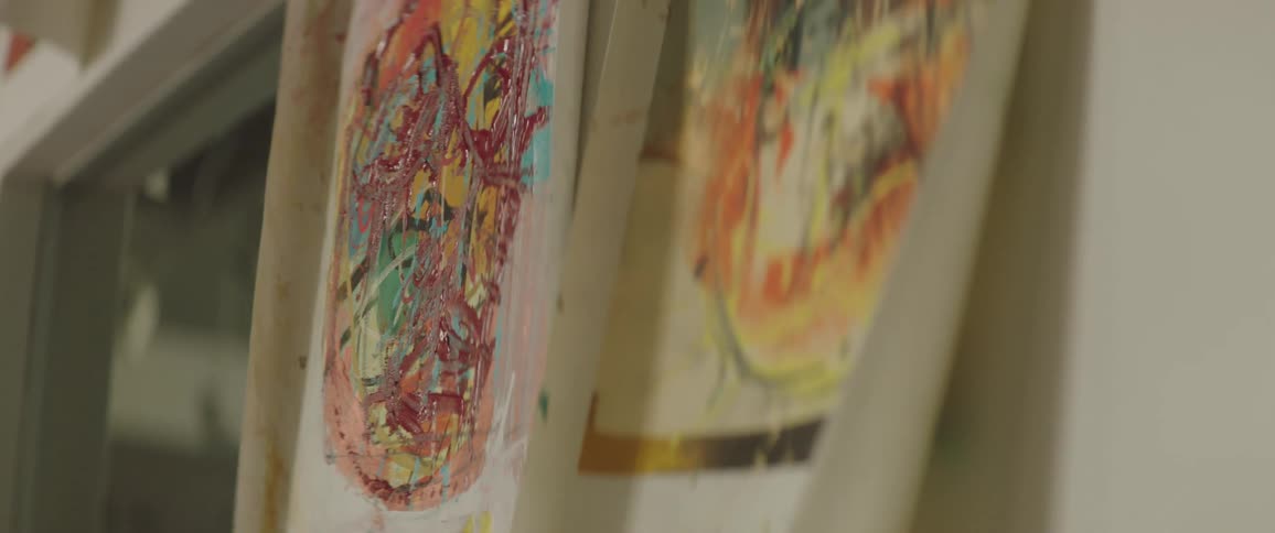 A pair of small abstract paintings are posted next to a doorway
