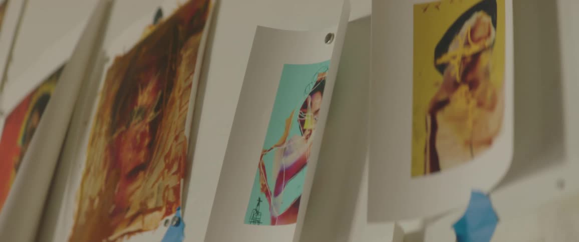 Various works of art taped to a wall