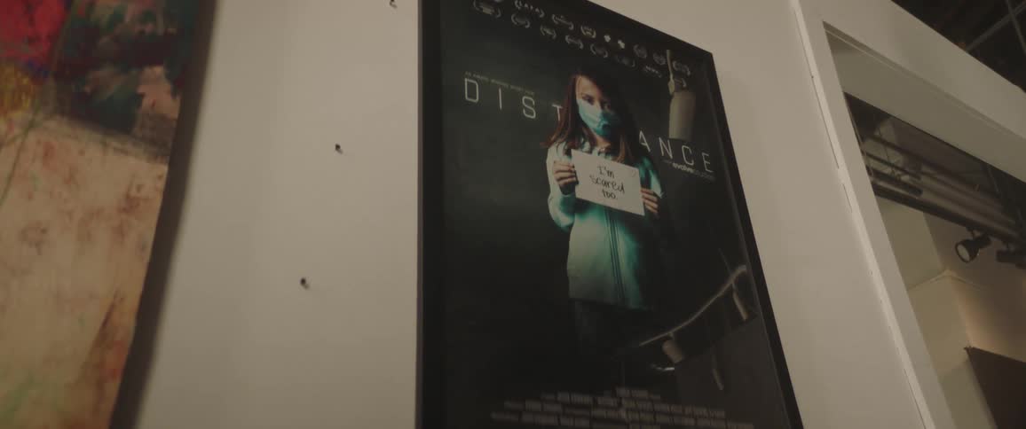 A room with a picture in picture frame with a wall and doorway in the background