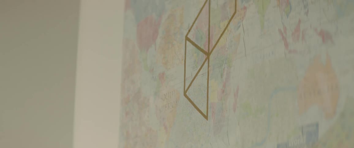 Logo of a hotel drawn over a world map taped on the wall