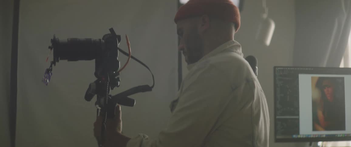 Photographer placing a camera on a tripod inside the studio