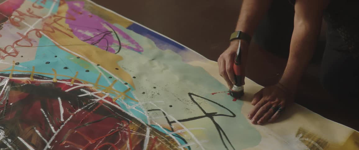 An artist is signing a painting with colors