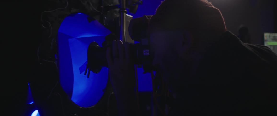 Lights flash as a man wearing a toque takes photos with a camera