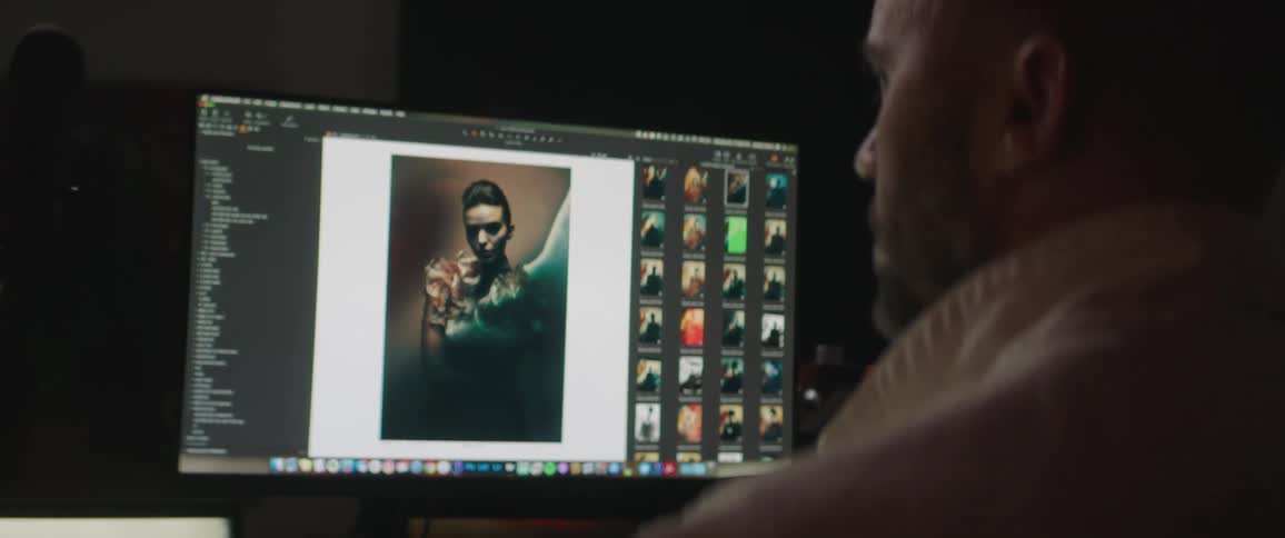 Designer working on photo editing in a computer inside a dimly lit office