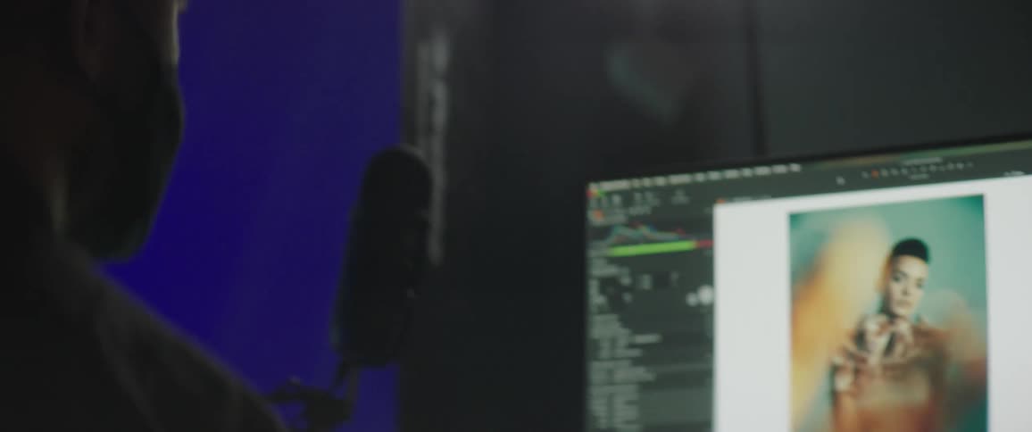 A man edits photos of a model on his computer