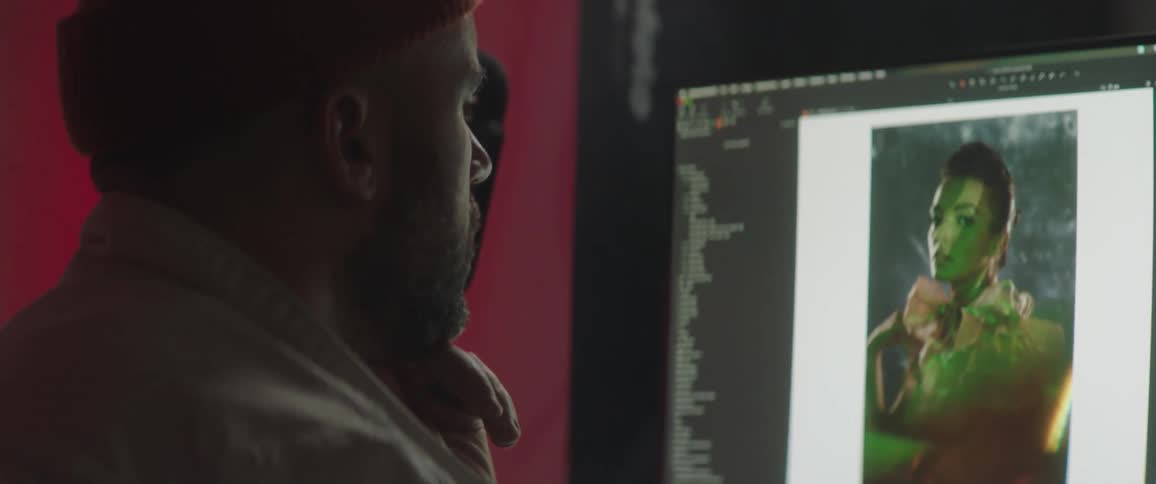 Photographer goes through fashion photos on monitor
