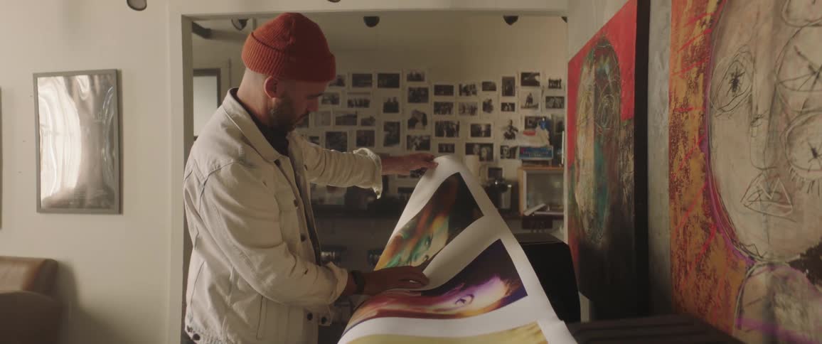 A man lifting his photos on a canvas
