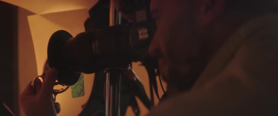 A photographer takes photos in a studio as lights flash red and green