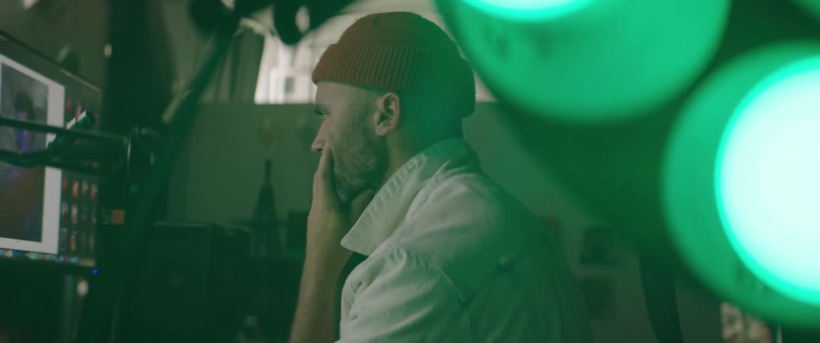 Photographer editing picutres on a computer inside a dimly lit studio