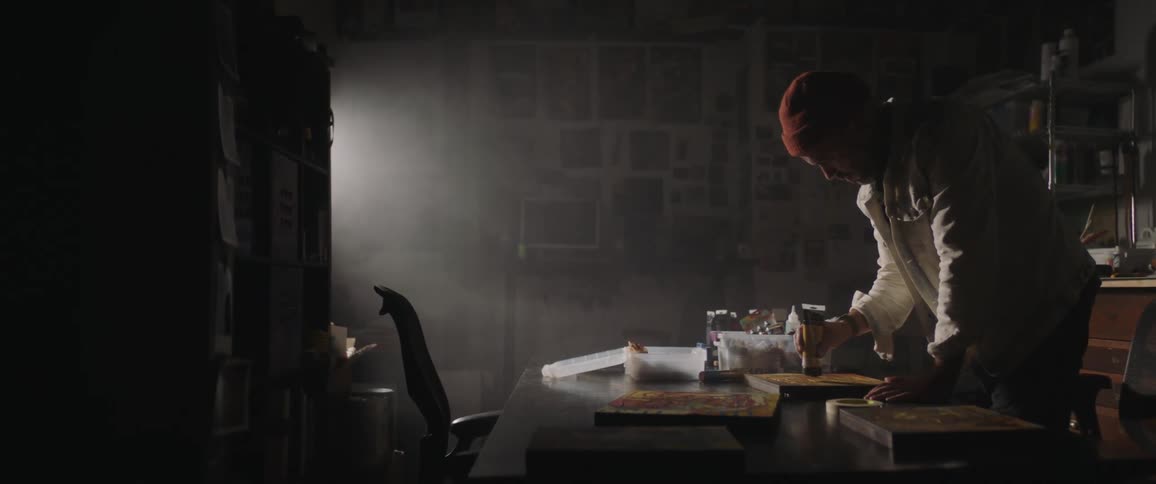 A man painting in a dark room