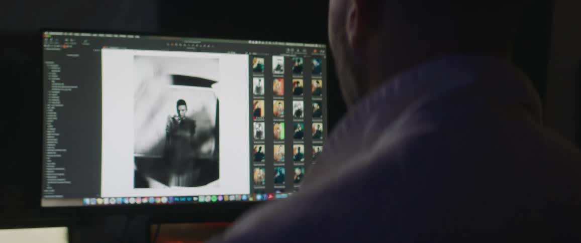 A man is flipping through photos on the computer
