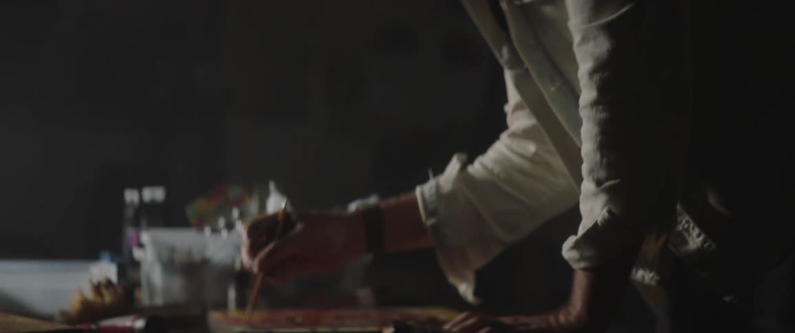A man painting in a dark room