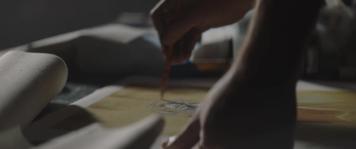 Artist adds paint topaper sitting on table