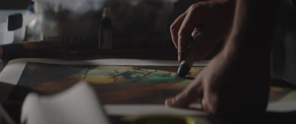 A person is painting on a small canvas