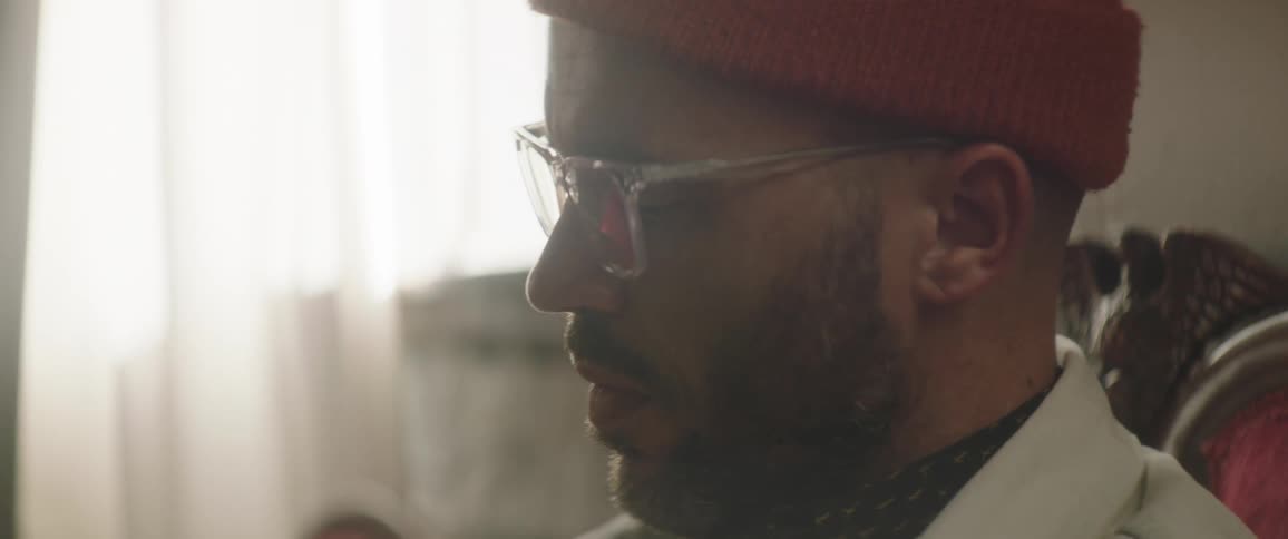 Man wearing glasses and a toque uses a stylus on a tablet