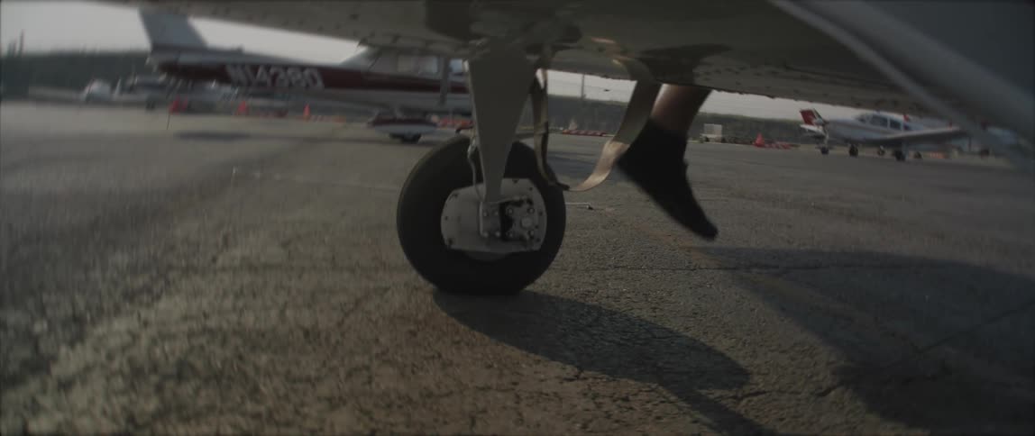 A person is stepping into a plane during midday