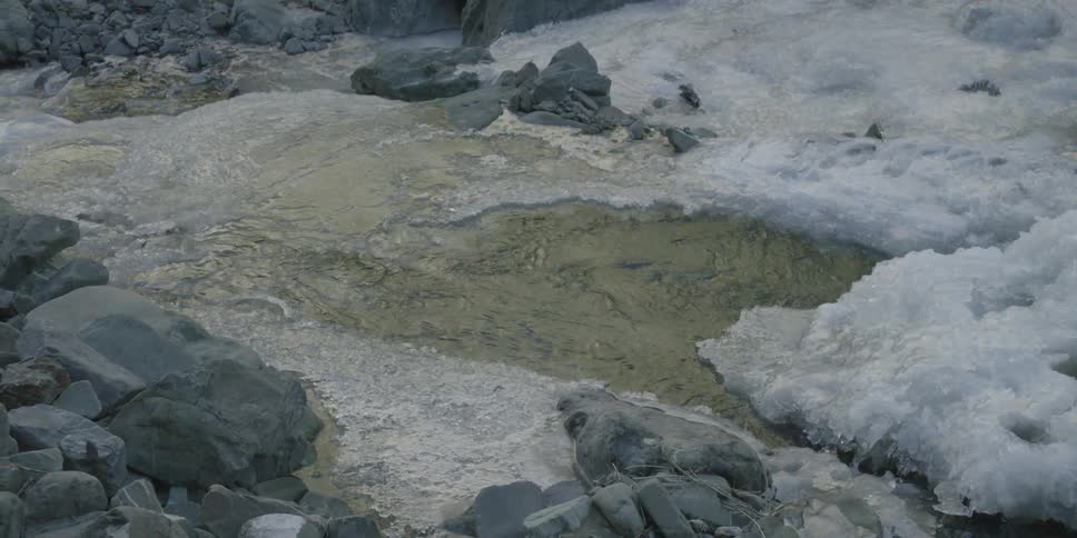 Water moves past a frozen landscape