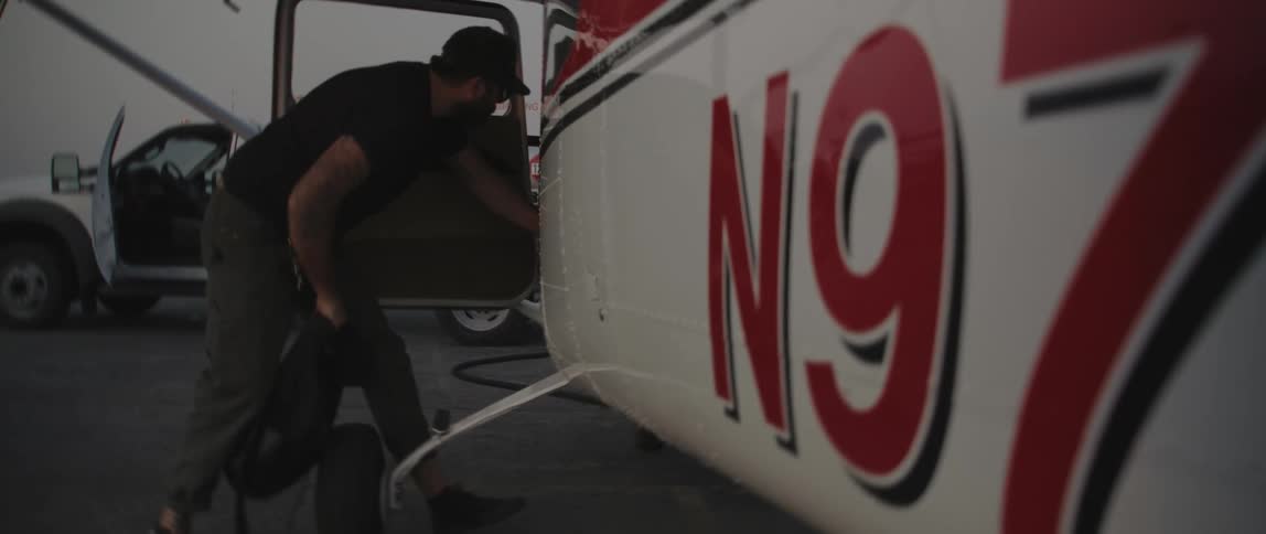 A man putting bags into an airplane