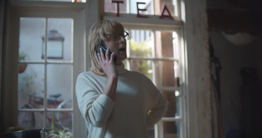 Woman talking on the phone on the living room at home