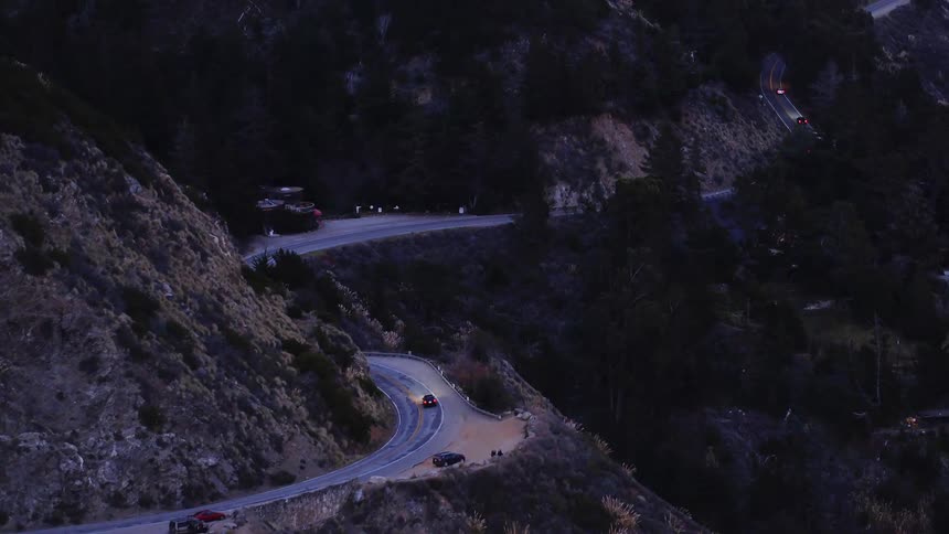 Vehicles drive on a winding mountain