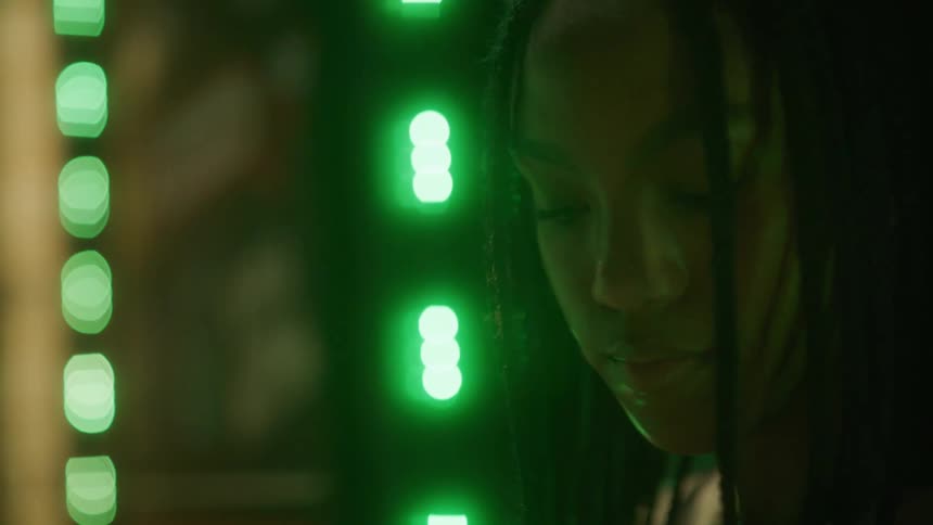 A woman standing near some lights at night