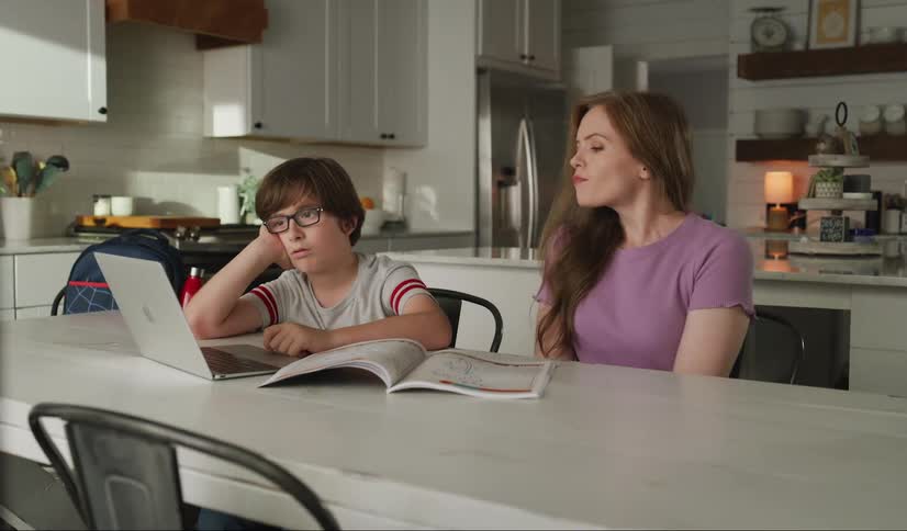 A woman helps a child do homework at home
