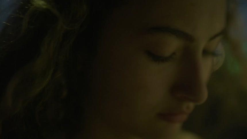 Wind blows through a womans long wavy hair as she stands outside at night