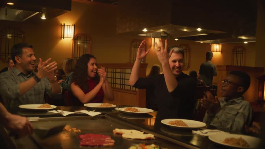 Chef at asian grill restaurant throws food and diner catches it to applause
