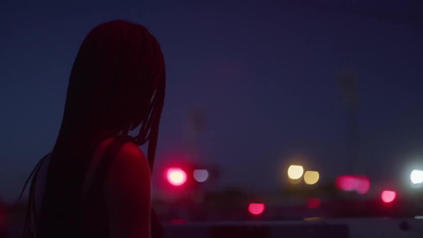 A woman is standing by the railroad tracks