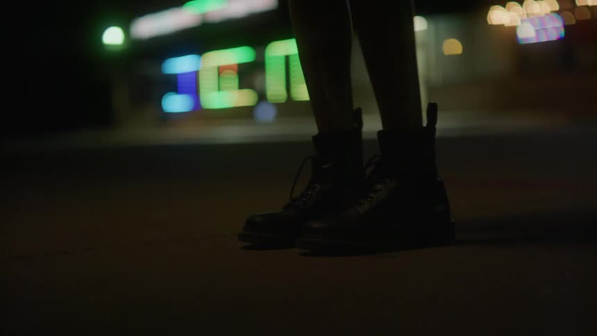A close up of womens boots outside at night