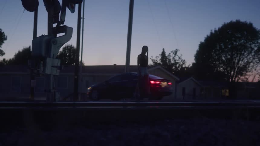 A woman walking outdoors at dusk