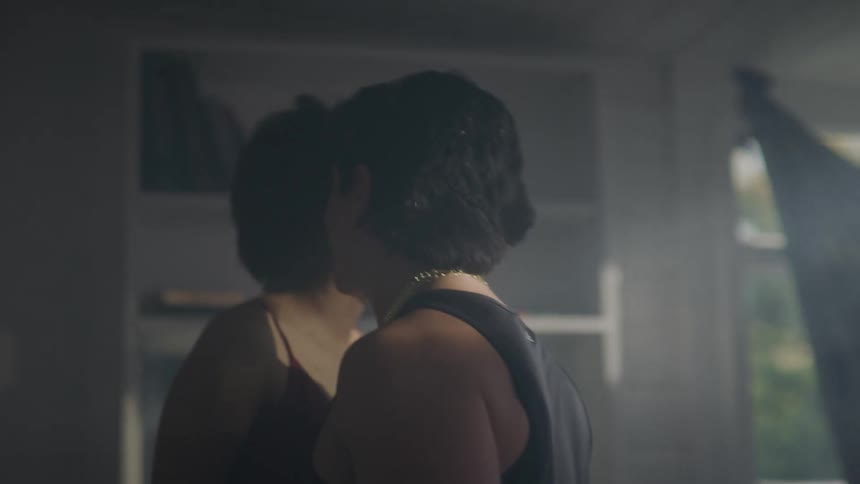 A man and a woman in a room dancing and drinking