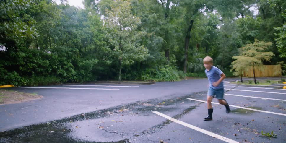 A child is running towards the puddle