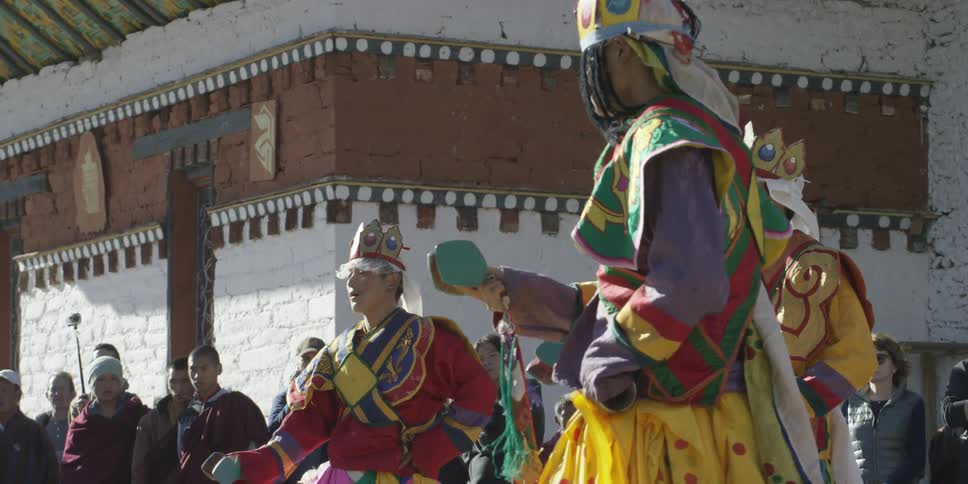 People in costumes perform as people watch