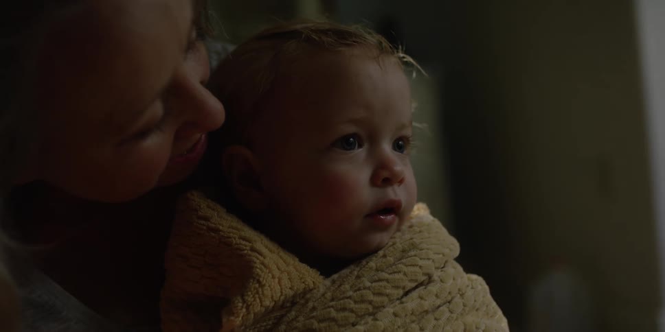 A mother holding their daughter in a towel