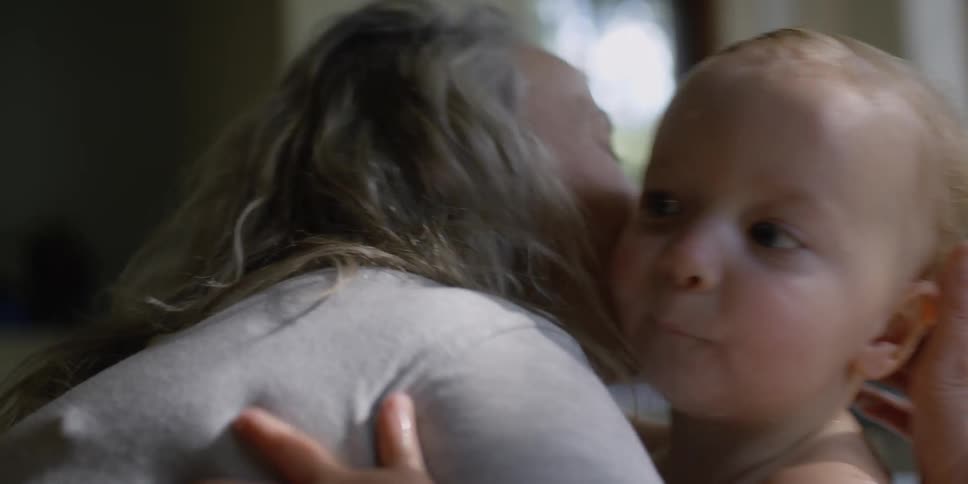 A woman holds and kisses a child