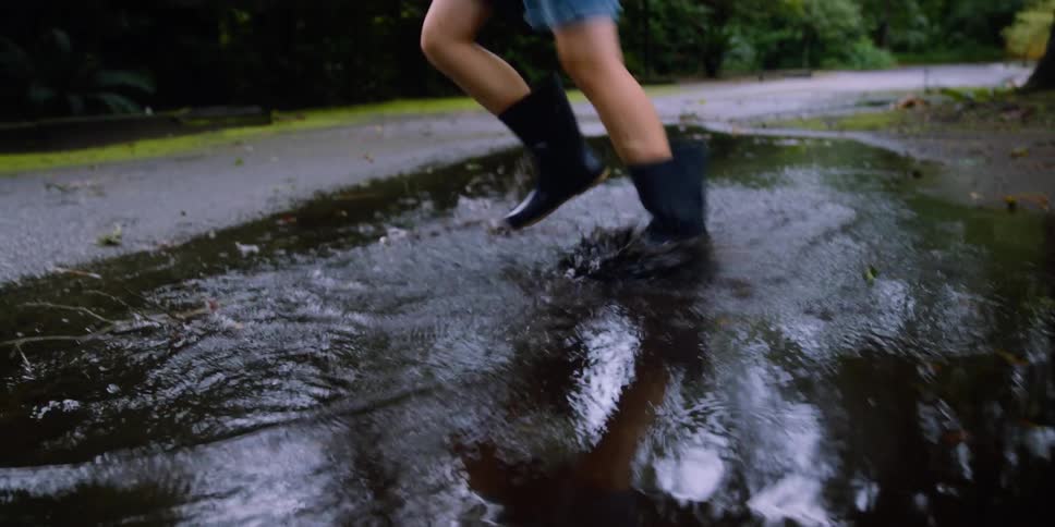 Two children splash around in the puddle