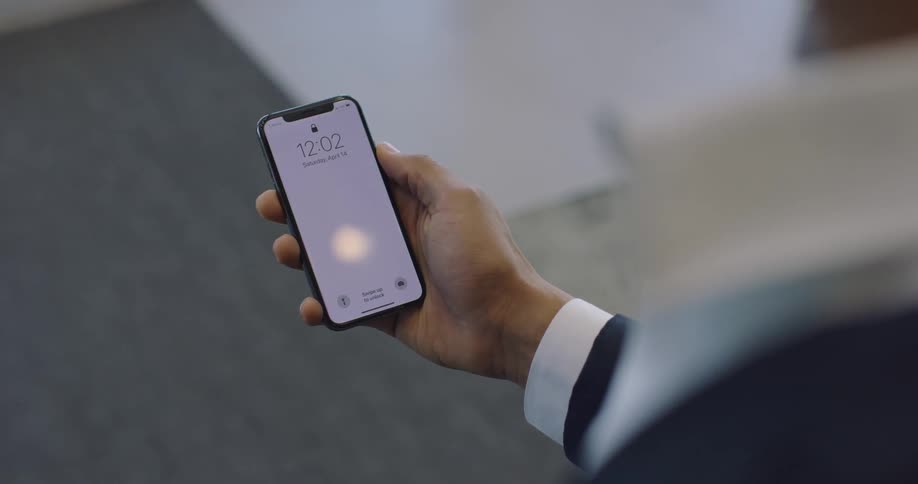 Man looks at the time on his cell phone