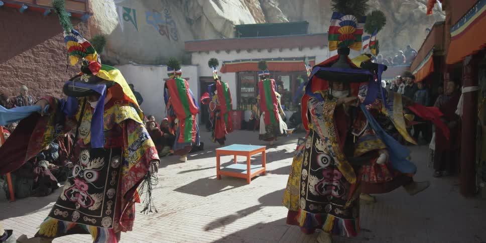 A group of people in costumes dance for an audience