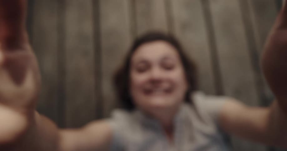 A woman smiling while waving her hands above her body