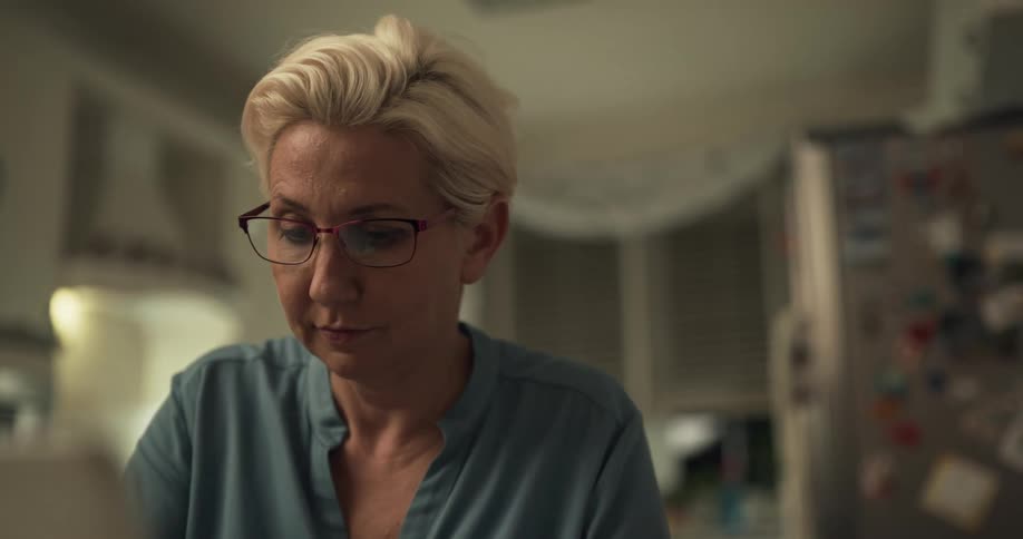 A woman with glasses concentrating while sitting at home