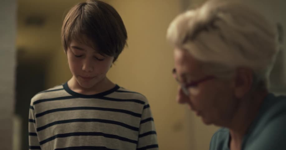 A boy asks a woman with help with his homework