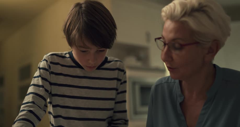 A grandmother speaking to her grandson indoors at home