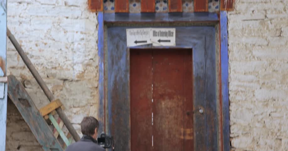 Panning down a brick wall with a many photographing below
