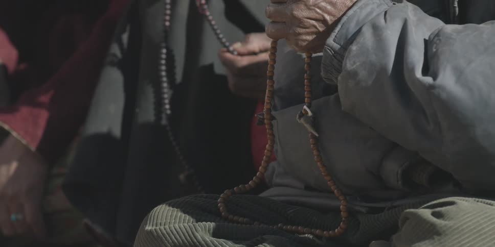 A person holds two strings of colored beads