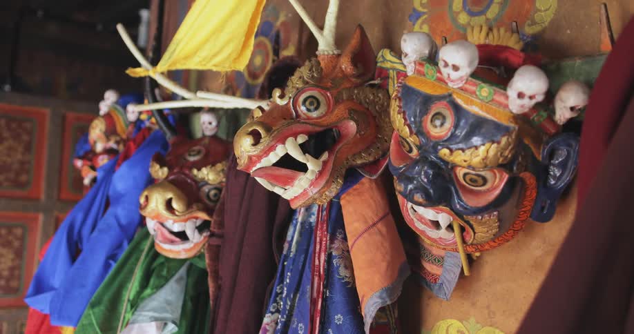 Colorful masks and scarves hung on a wall