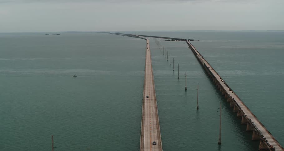 Cars drive across the bridge on the water