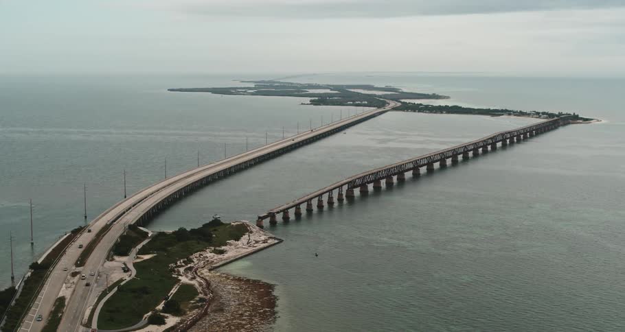 Vehicles driving on a bridge over the islands in the ocean