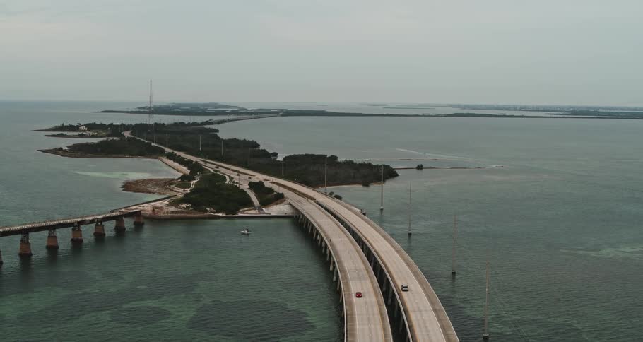 A bridge that is part of a freeway starts from an island and extends over a large body of water